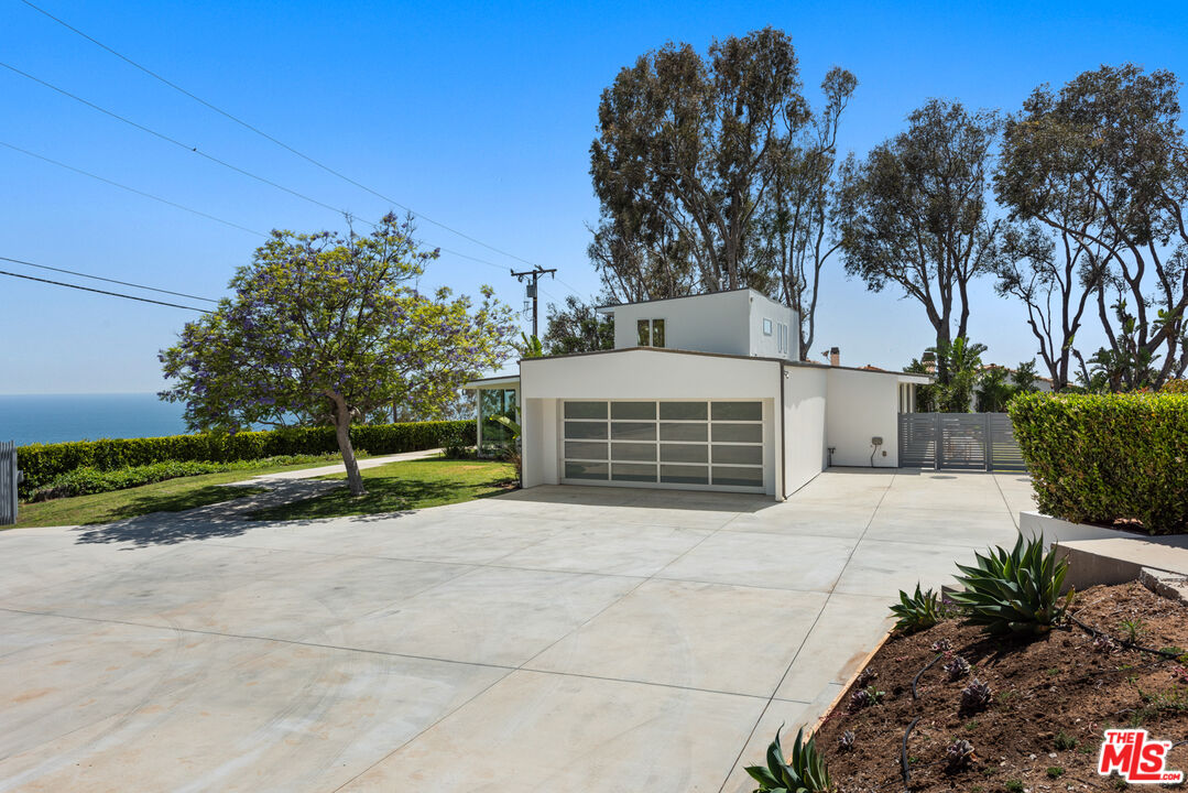 3431 Coast View Drive Malibu, CA 90265 - Photo 6 of 49 a front view of a house with a yard and garage