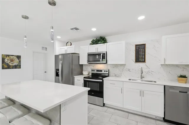 a kitchen with a sink stainless steel appliances and cabinets