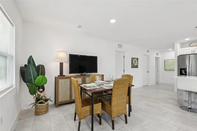 a living room with furniture kitchen view and a window