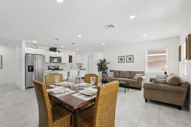 a living room with furniture a flat screen tv and a window