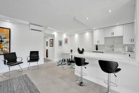 a living room with furniture a fireplace and a dining table with wooden floor