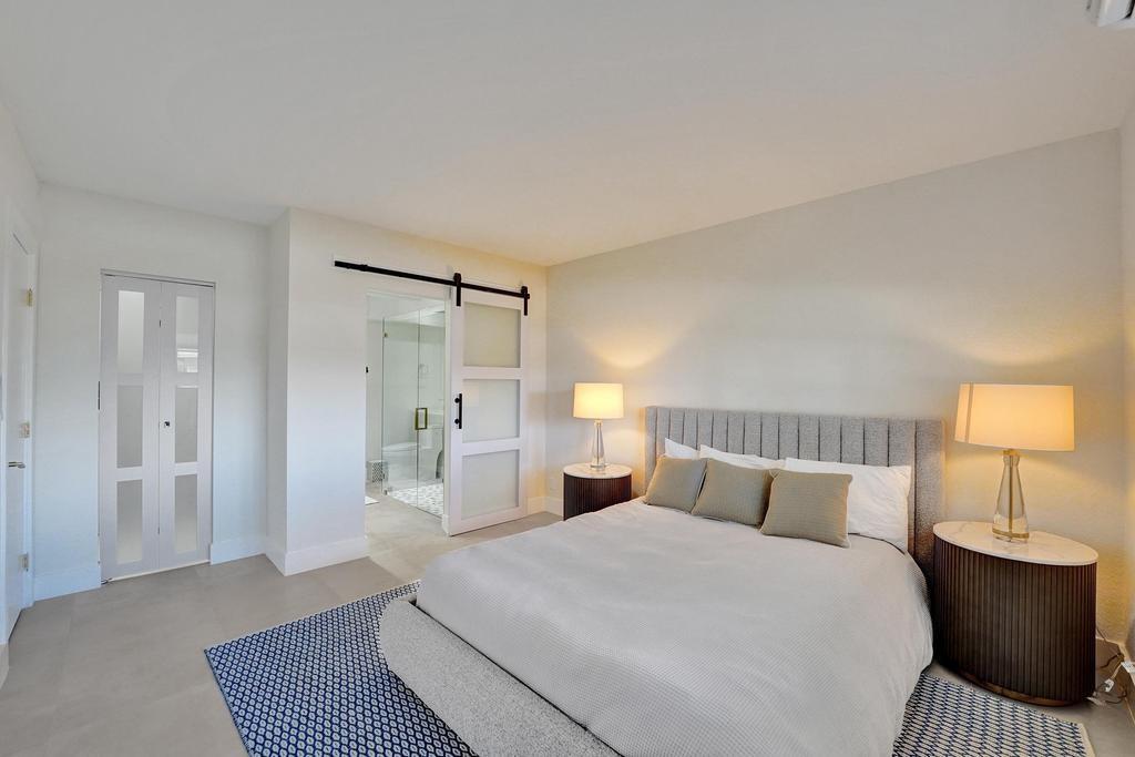 2866 Northeast 30th Street, Unit 9 Fort Lauderdale, FL 33306 - Photo 24 of 54 a bedroom with a bed and wooden floor