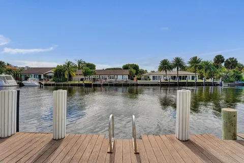 a view of a lake with boats and palm trees