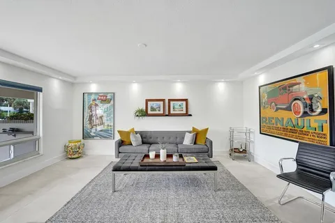 a living room with furniture and a painting on the wall