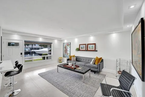 a living room with furniture a flat screen tv and a large window