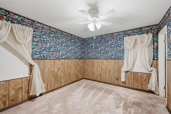 en empty room with wooden floor and fan
