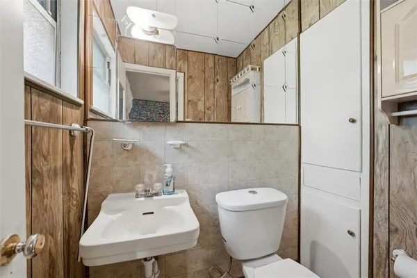 a bathroom with a toilet sink and mirror