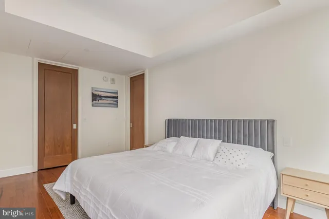 a bed sitting in a bedroom and wooden floor