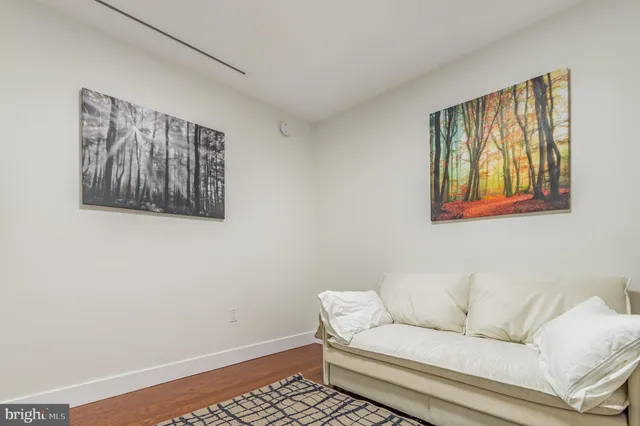 a living room with furniture and a wall painting
