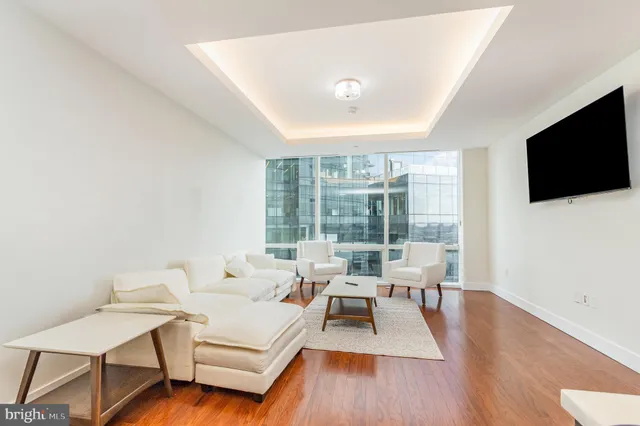 a living room with furniture wooden floor and a flat screen tv