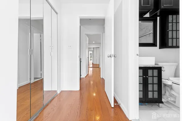a view of a hallway with wooden floor and staircase