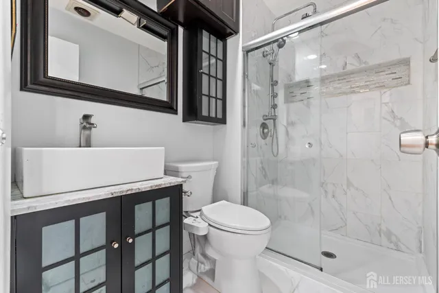 a bathroom with a sink a toilet and shower