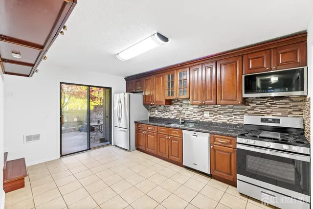 a kitchen with stainless steel appliances granite countertop a stove sink and microwave