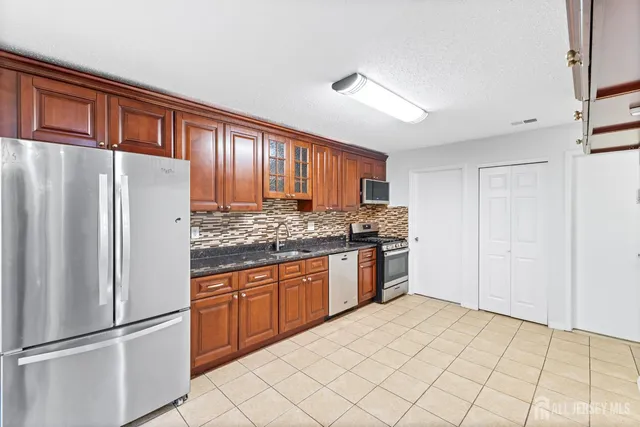 a kitchen with stainless steel appliances granite countertop a refrigerator and a sink