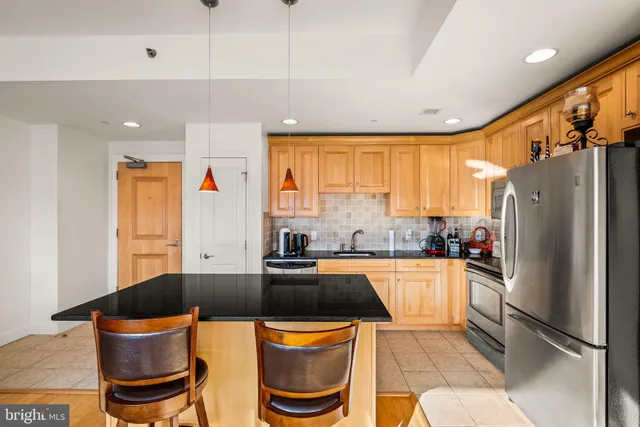 a kitchen with granite countertop a sink appliances and cabinets
