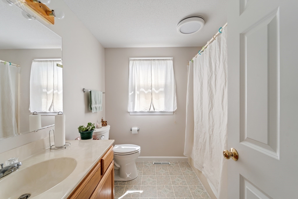184 Russell Street Springfield, MA 01104 - Photo 8 of 28 a bathroom with a granite countertop sink toilet a mirror and shower