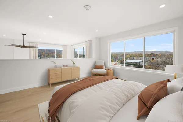a bedroom with bed and a large window