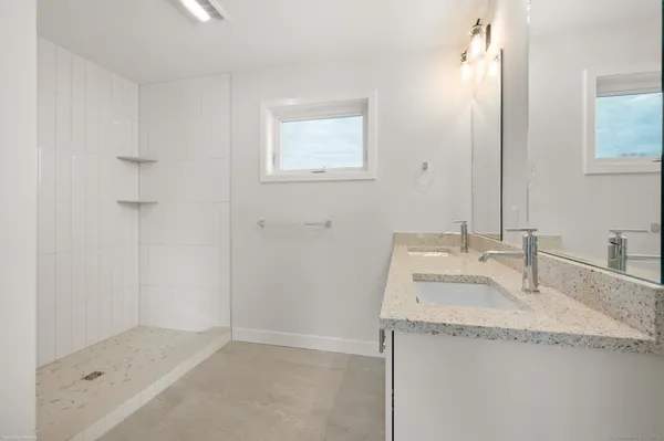 a bathroom with a granite countertop sink and a mirror