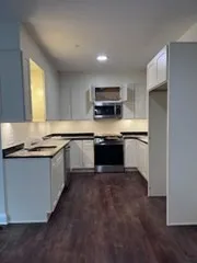 a kitchen with stainless steel appliances granite countertop a sink and a stove