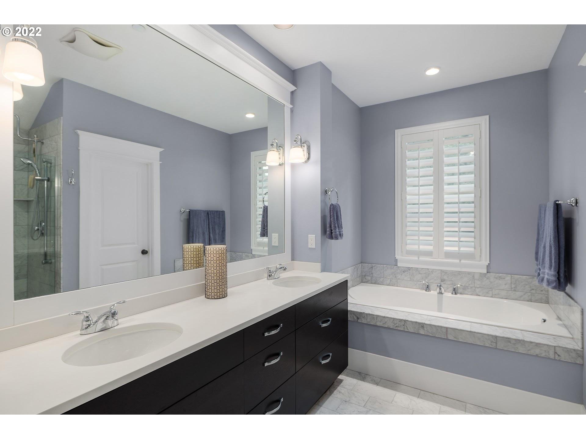 10460 Southwest Windwood Way Portland, OR 97225 - Photo 17 of 29 a bathroom with a tub double sink shower and mirror