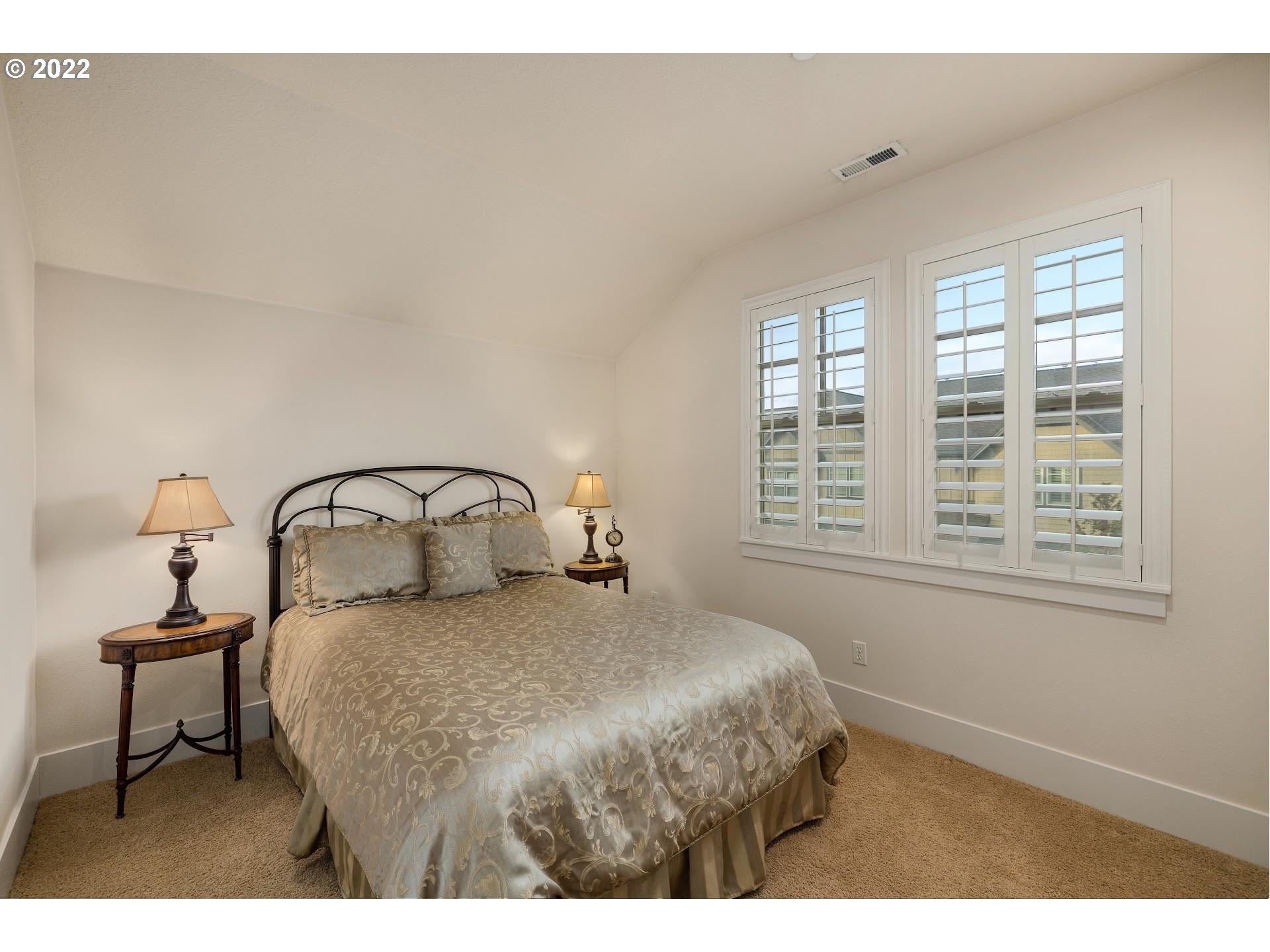 10460 Southwest Windwood Way Portland, OR 97225 - Photo 22 of 29 a bedroom with a bed and a window with a mirror