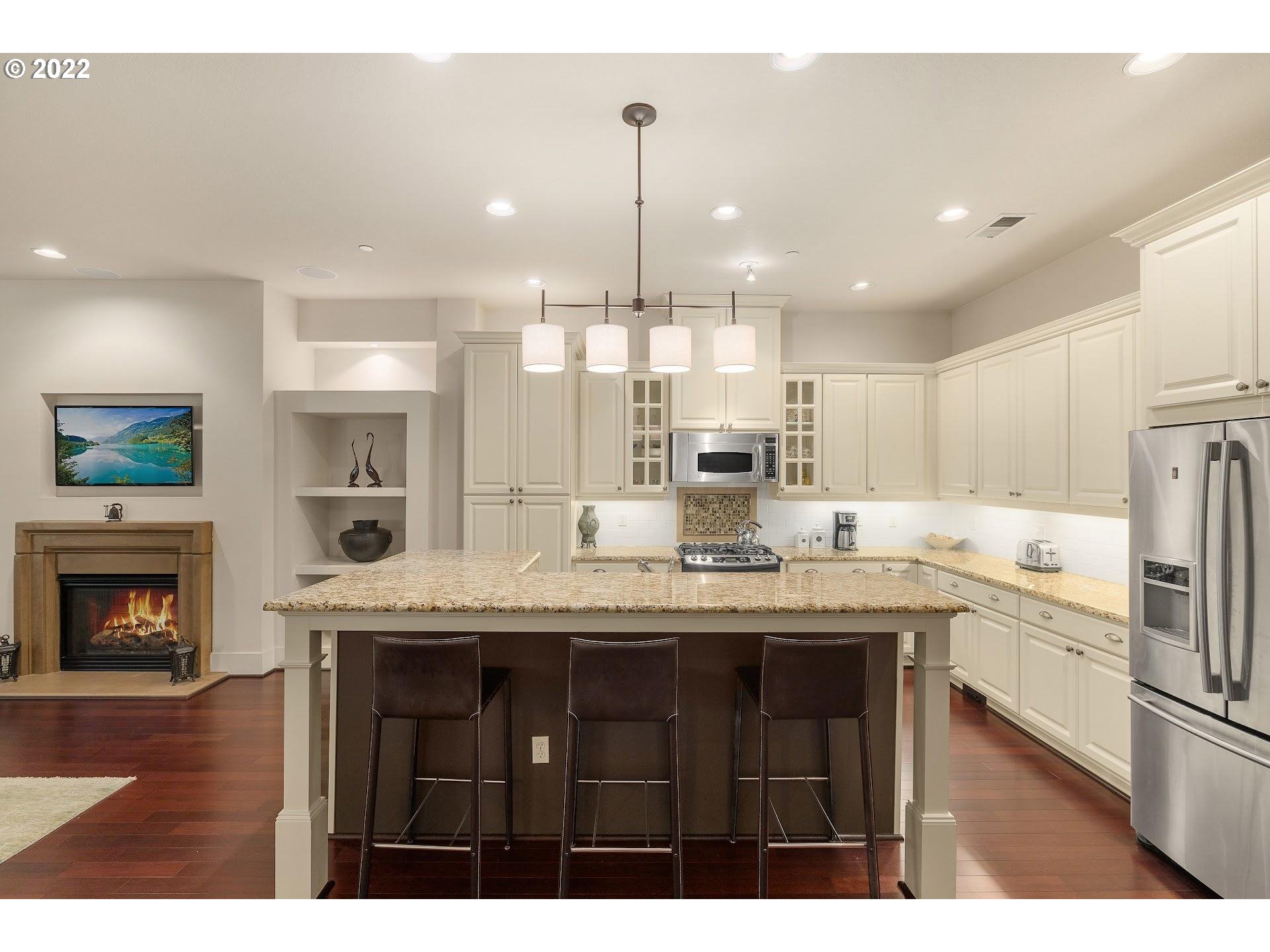 10460 Southwest Windwood Way Portland, OR 97225 - Photo 5 of 29 a kitchen with stainless steel appliances granite countertop a sink a stove and a wooden floors