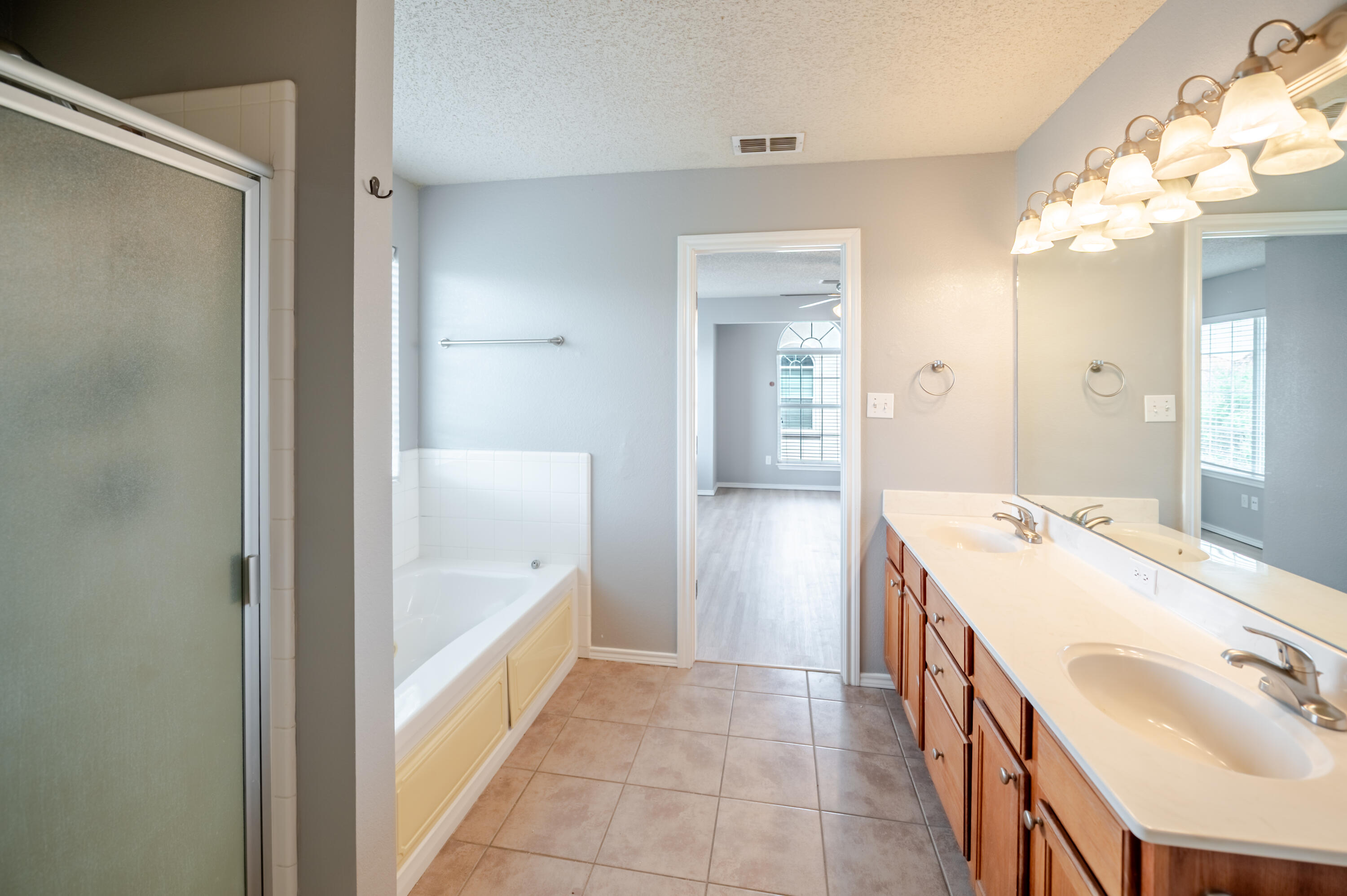 2111 Main Street, Unit 1 Lubbock, TX 79401 - Photo 24 of 36 a spacious bathroom with a tub sink and mirror