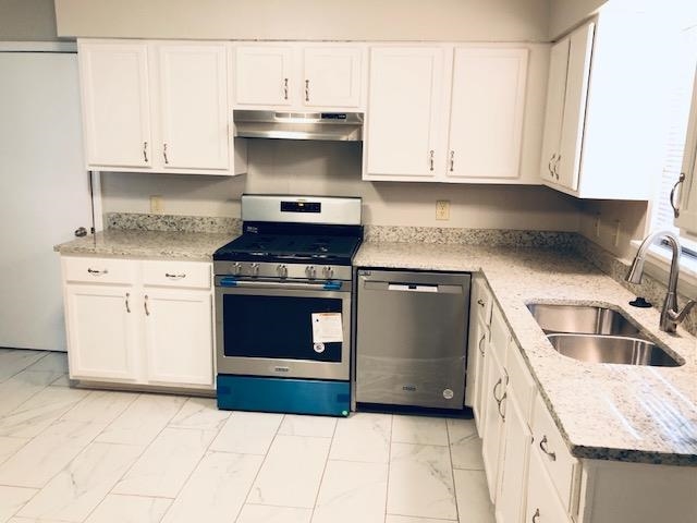 1381 Old Hickory Road Memphis, TN 38116 - Photo 13 of 24 a kitchen with a stove and white cabinets