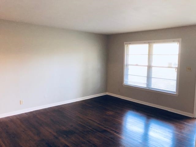 1381 Old Hickory Road Memphis, TN 38116 - Photo 10 of 24 a view of an empty room with wooden floor and a window