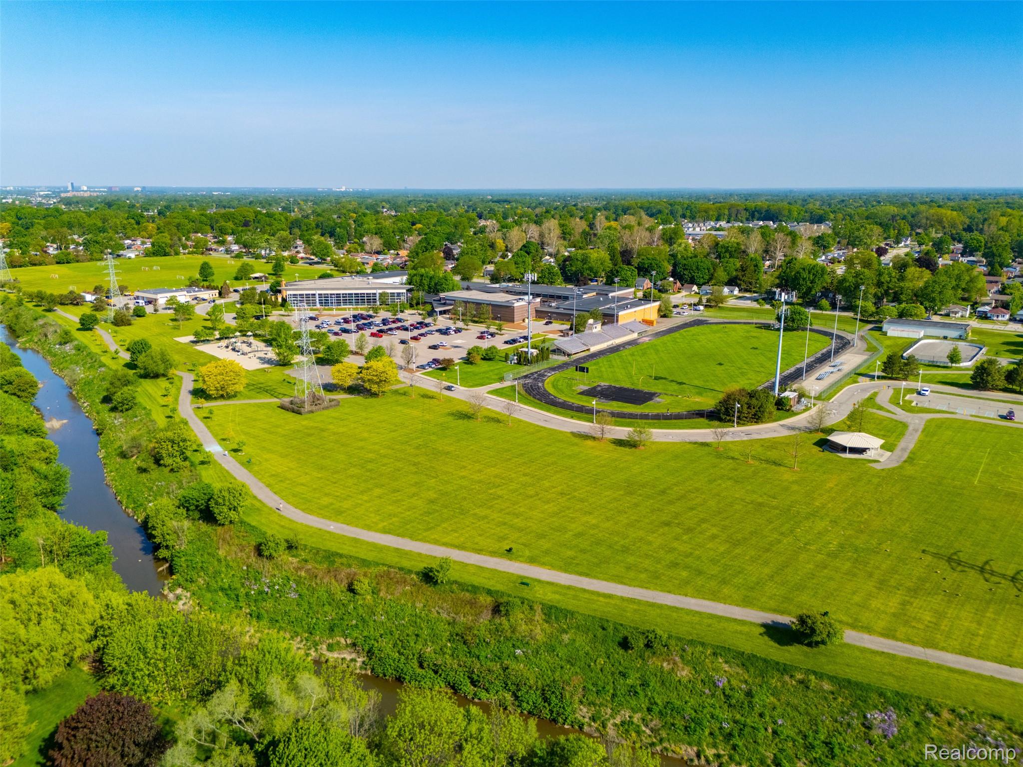 5634 Chicago Road Warren, MI 48092 - Photo 34 of 36 Warren Community Center - Expansive green spaces featuring a winding waterway (Red Run), paved walking paths, and mature landscaping