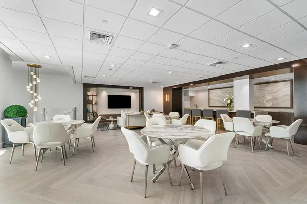 a view of a swimming pool with a lawn chairs and palm trees