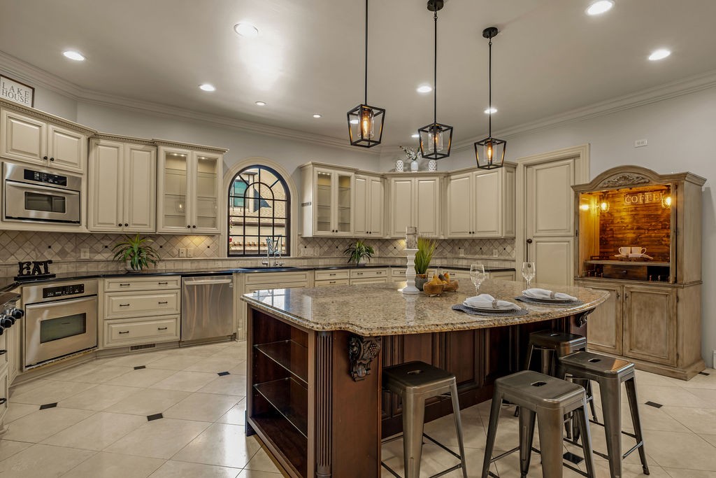 110 Devan Kishan Way Mount Juliet, TN 37122 - Photo 21 of 76 a kitchen with stainless steel appliances granite countertop a stove top oven a sink a dining table and chairs with wooden floor