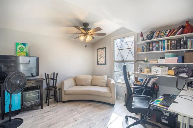 a living room with furniture a rug and a bookshelf