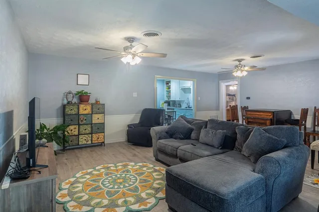 a living room with furniture and wooden floor