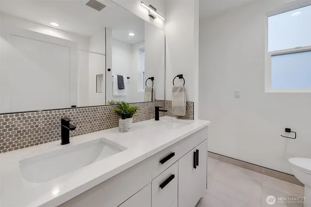 a bathroom with a granite countertop sink a toilet and a bathtub