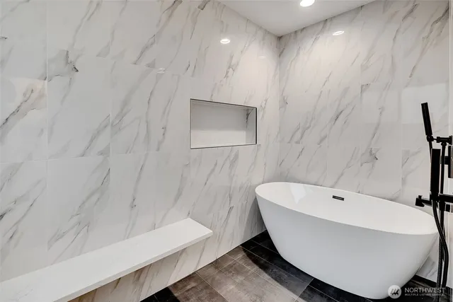 a bathroom with a white tub sink and vanity