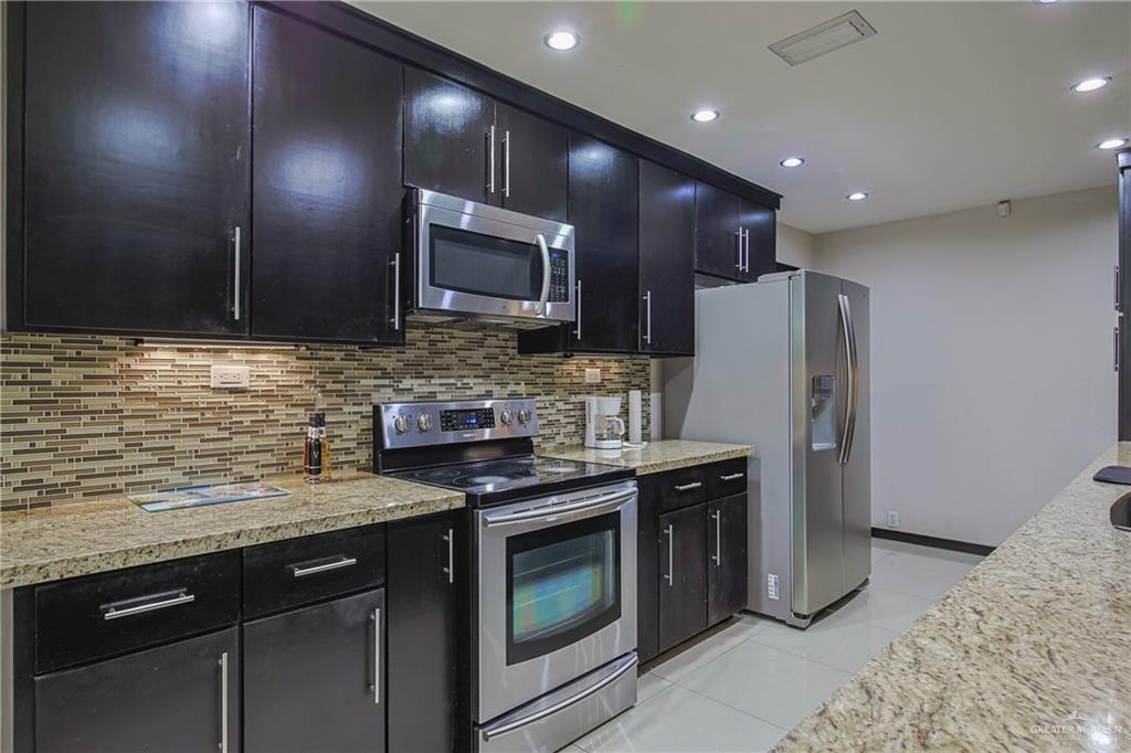 412 Toronto Avenue, Unit 34 McAllen, TX 78503 - Photo 11 of 44 Kitchen with dark cabinetry, stainless steel appliances, light tile patterned floors, recessed lighting, and backsplash