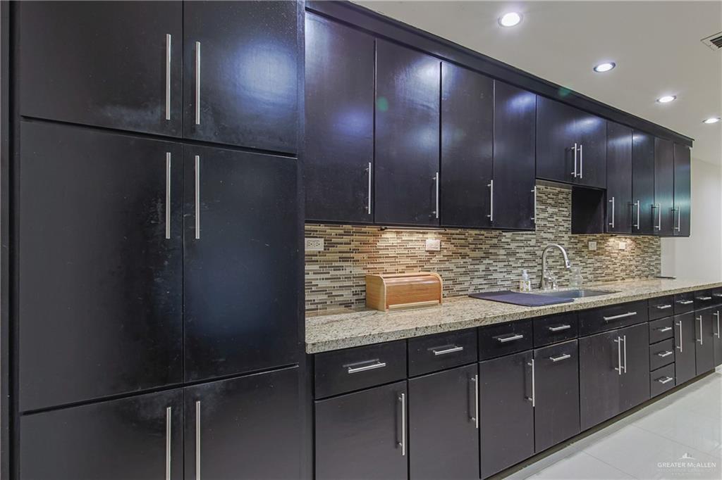 412 Toronto Avenue, Unit 34 McAllen, TX 78503 - Photo 13 of 44 Kitchen featuring backsplash, dark cabinets, light tile patterned floors, light stone countertops, and recessed lighting
