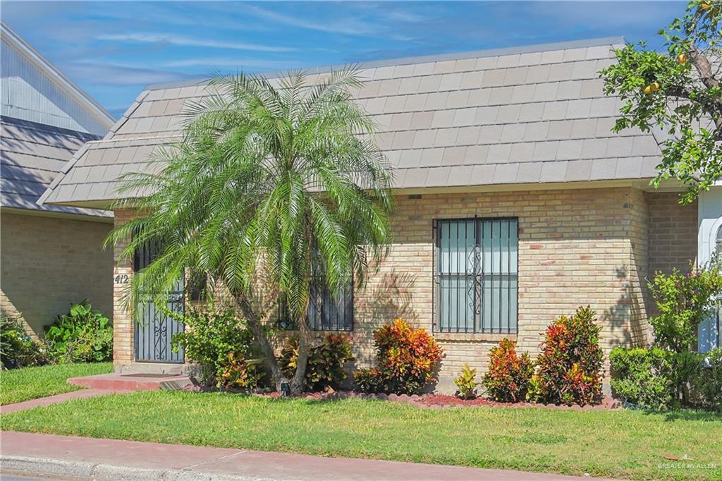 412 Toronto Avenue, Unit 34 McAllen, TX 78503 - Photo 3 of 44 View of side of property featuring brick siding and a lawn