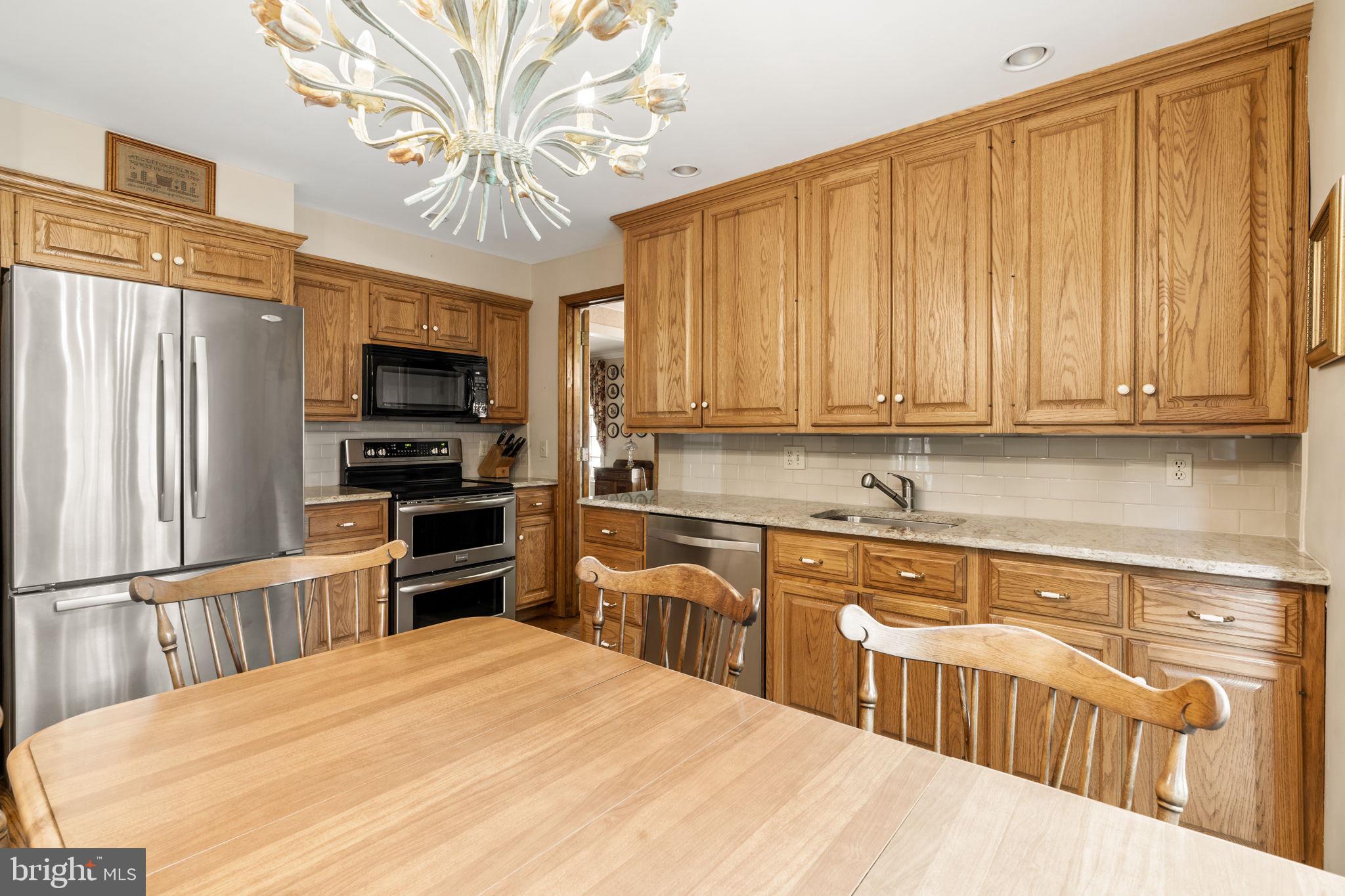 16 Whitby Road Cherry Hill, NJ 08003 - Photo 12 of 28 a kitchen with kitchen island granite countertop a stove top oven microwave and cabinets