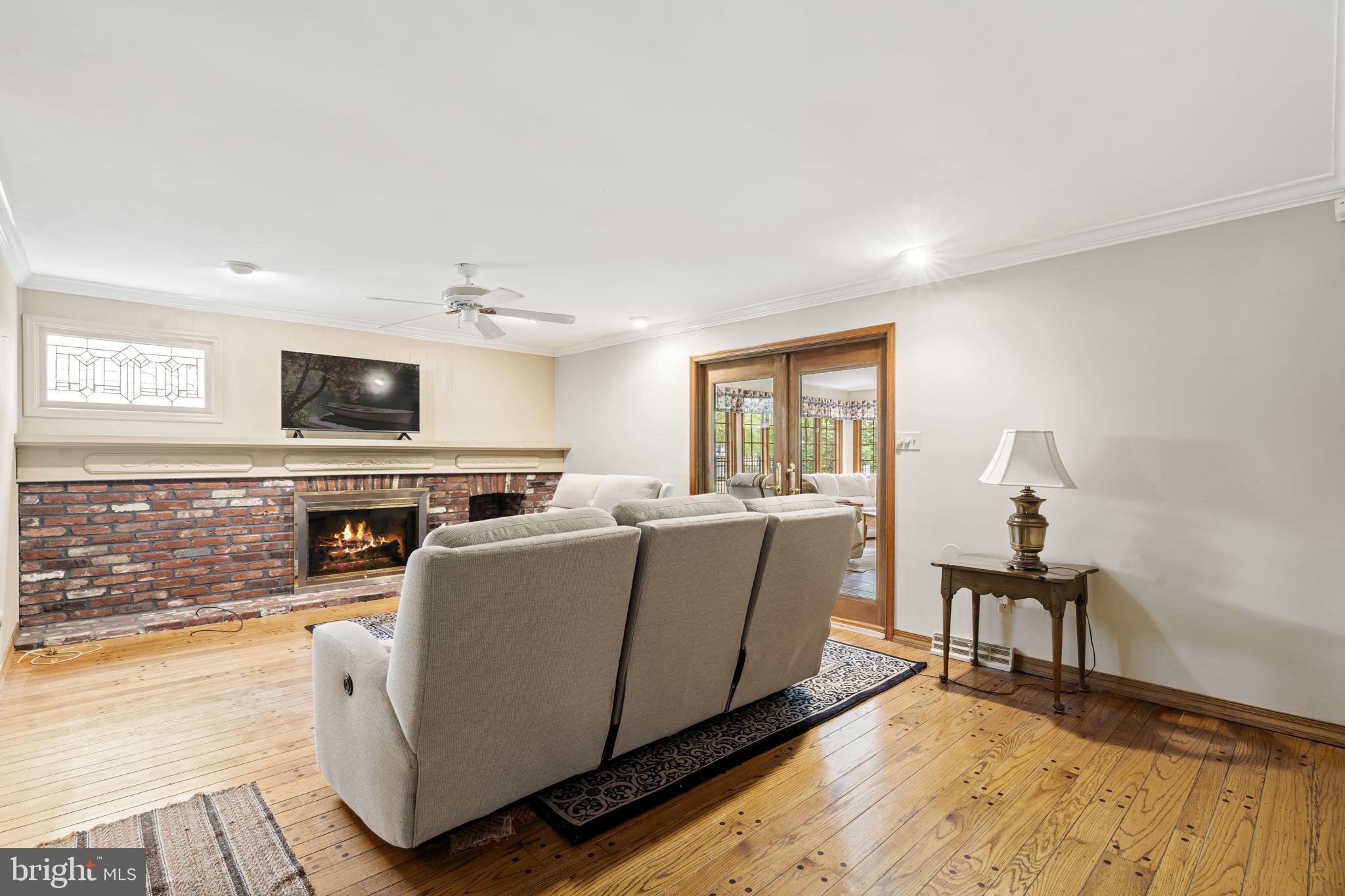 16 Whitby Road Cherry Hill, NJ 08003 - Photo 13 of 28 a living room with furniture a flat screen tv and a floor to ceiling window