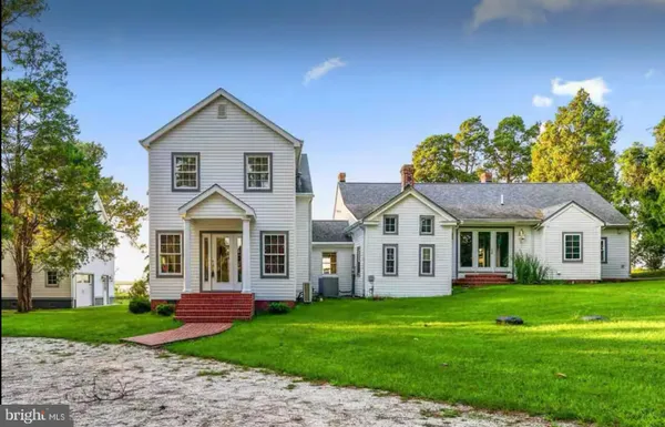 a front view of a house with a garden and trees