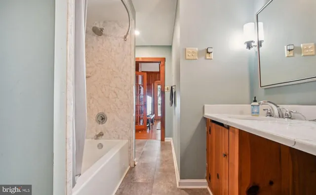 a bathroom with a tub sink and mirror