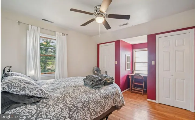 a bedroom with a bed and wooden floor