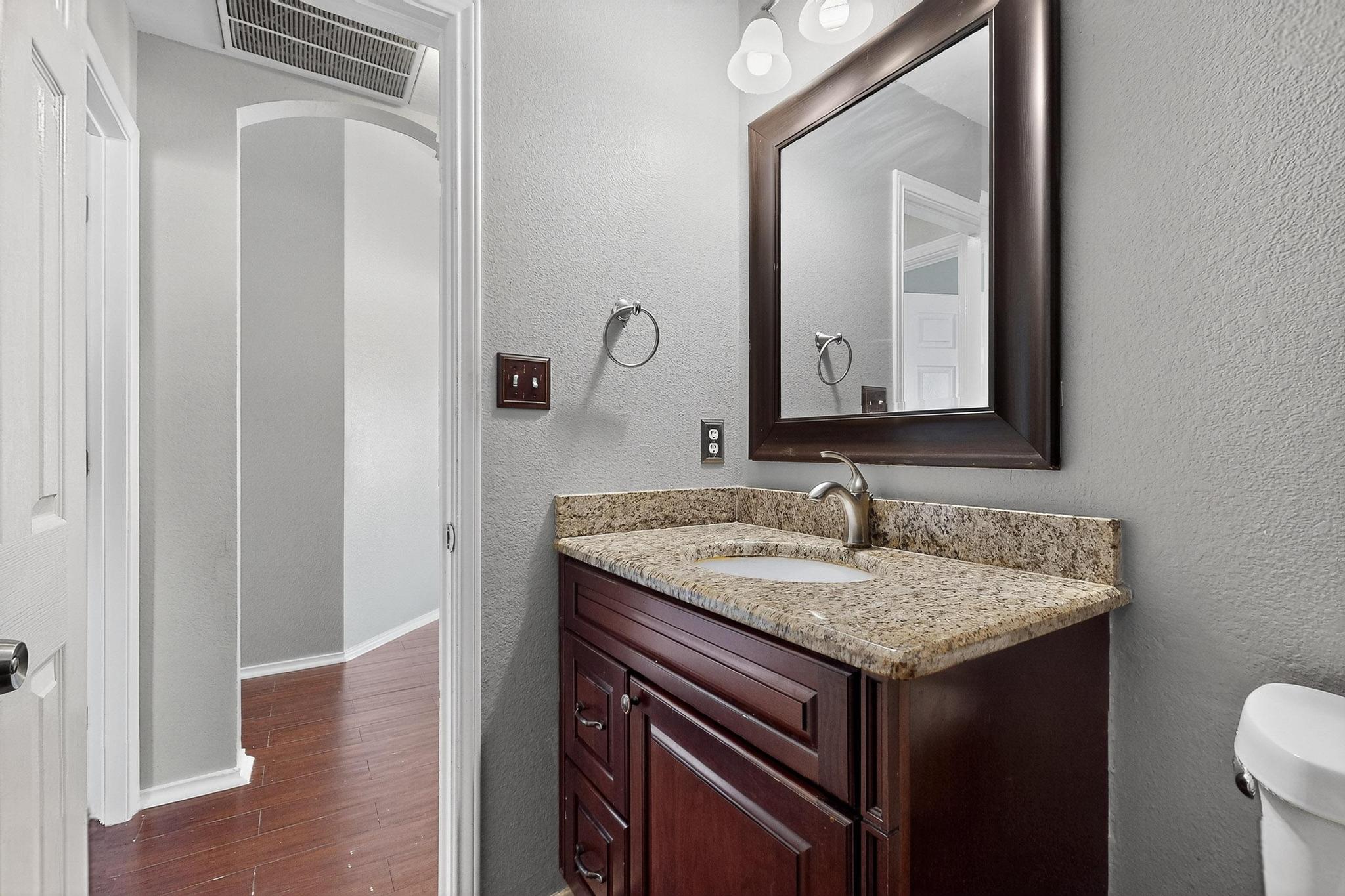 2403 Willow Way Round Rock, TX 78664 - Photo 34 of 35 Half bath with a textured wall, vanity, and dark wood finished floors