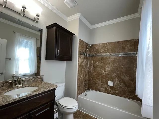 a bathroom with a granite countertop sink toilet and shower