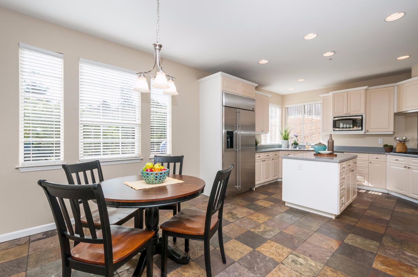 1 Ralston Ranch Road Belmont, CA 94002 - Photo 10 of 27 a kitchen with a dining table chairs refrigerator and cabinets