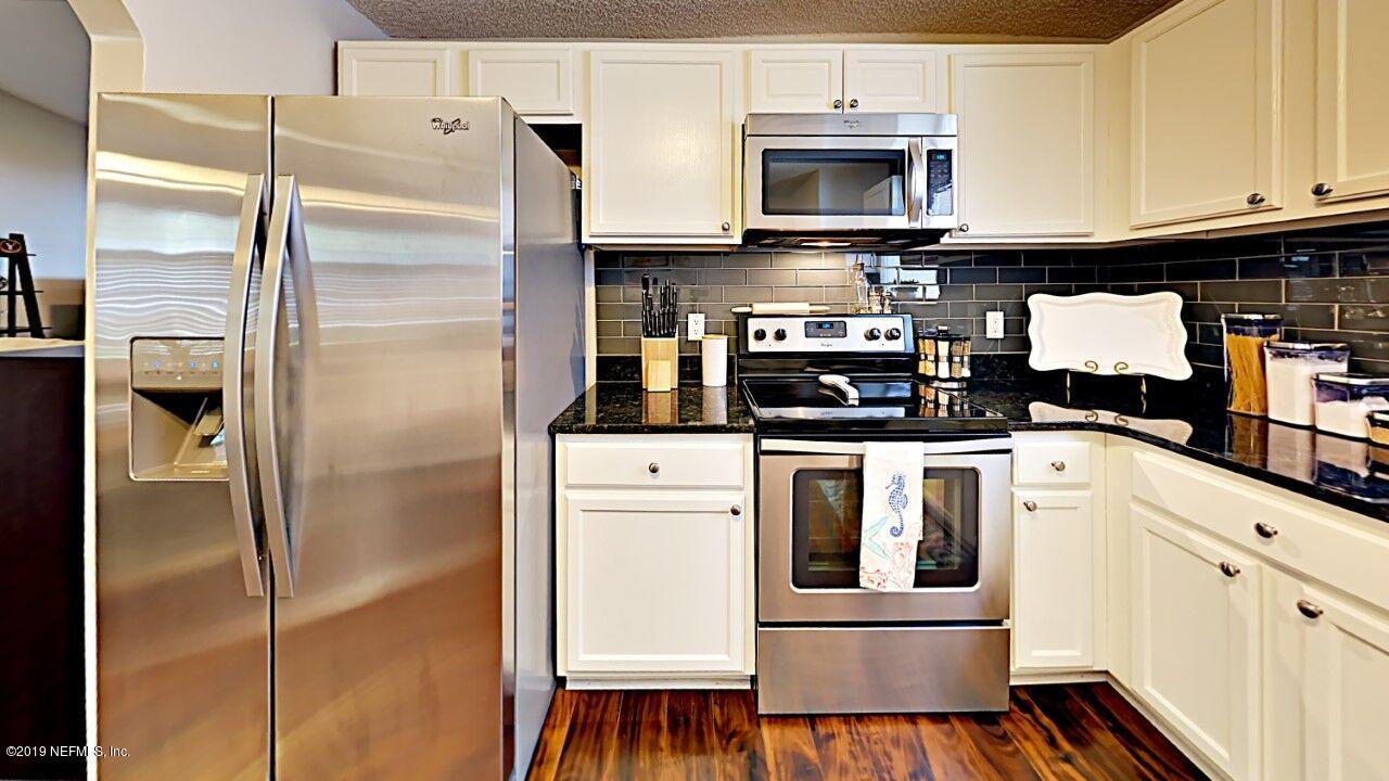 12830 Moose Road Jacksonville, FL 32226 - Photo 13 of 31 a kitchen with stainless steel appliances granite countertop a refrigerator a stove and a sink with wooden floor