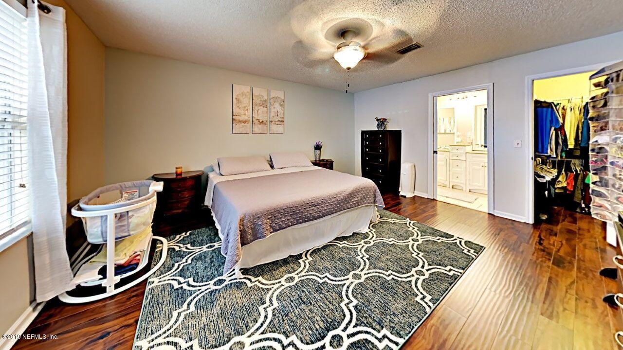 12830 Moose Road Jacksonville, FL 32226 - Photo 19 of 31 a bedroom with a bed and wooden floor