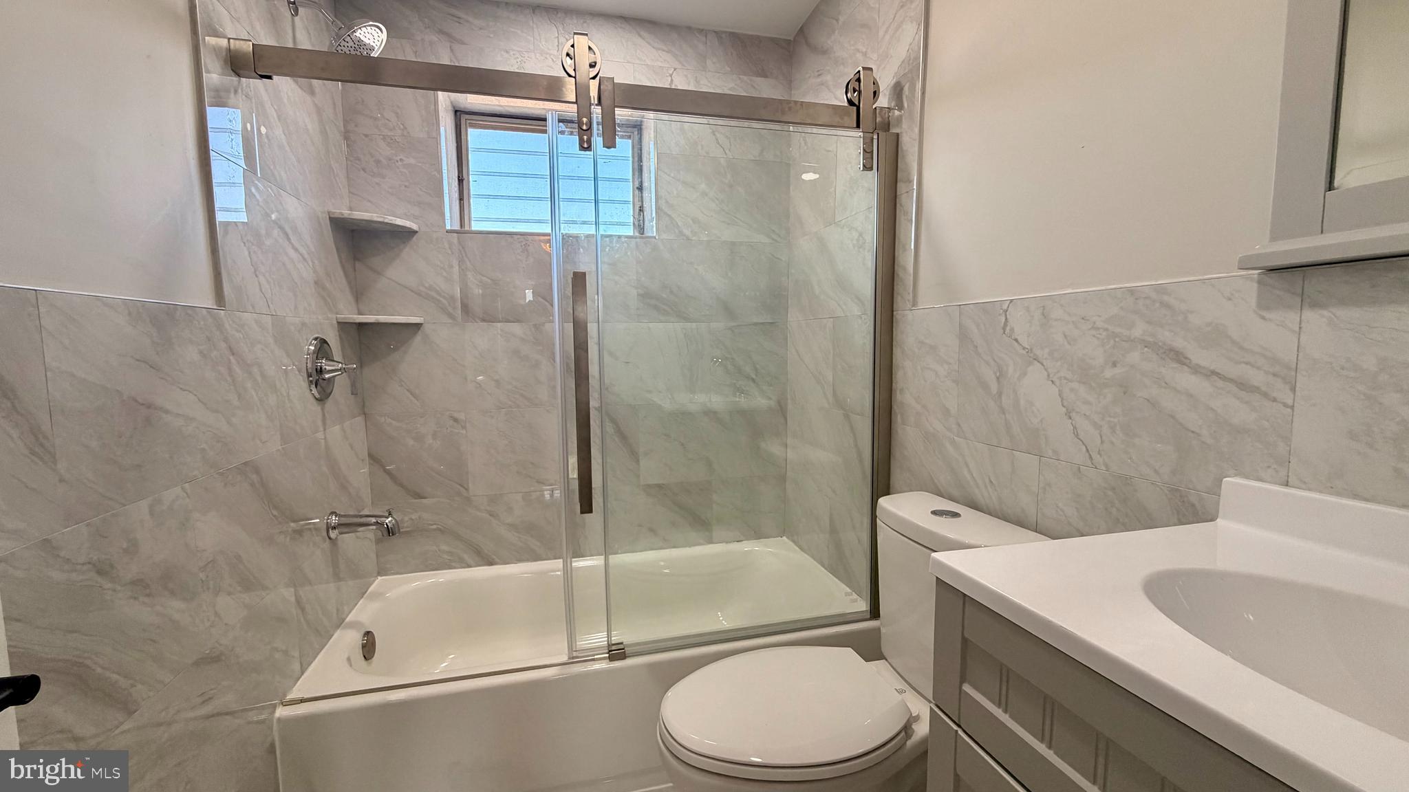 7219 Saul Street Philadelphia, PA 19149 - Photo 13 of 24 a bathroom with a white toilet sitting next to a bathroom sink and a shower